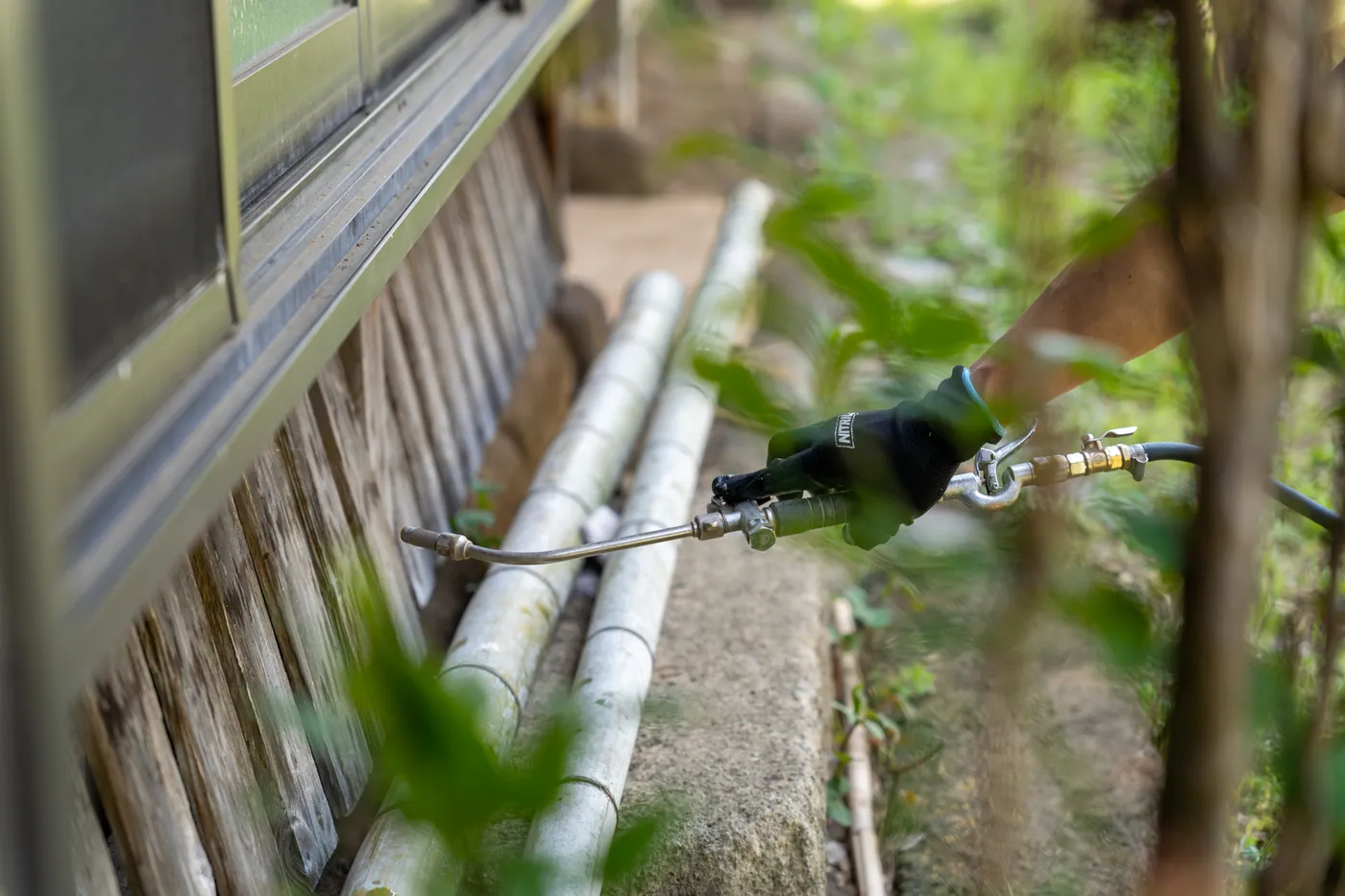 建物の外周でシロアリ防除処理を行う様子